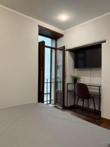 a bedroom with a bed and a chair and a television at FRASCATI Suites in Frascati