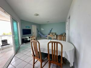 a dining room with a table and four chairs at Apt com vista para o mar e churrasqueira in Guaratuba