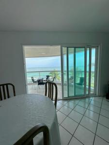 a dining room with a table and a view of the ocean at Apt com vista para o mar e churrasqueira in Guaratuba