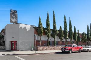 a red truck parked in front of a building with trees at Studio Lodge Hotel in Hewitt