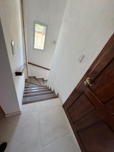 a hallway with stairs and a door and a window at Casa cairo in Ostende