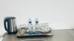 a tray with water bottles and cups on a counter at Gem Villa Inn in Lesoma