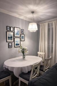 a dining room with a white table and chairs at EUROPA22 Apartament z JACUZZI w samym sercu miasta Tomaszów Maz - balkon z widokiem na park i fontanny Szybkie zameldowanie od 13 in Tomaszów Mazowiecki