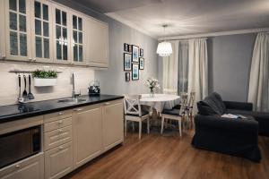 a kitchen and living room with a table and a couch at EUROPA22 Apartament z JACUZZI w samym sercu miasta Tomaszów Maz - balkon z widokiem na park i fontanny Szybkie zameldowanie od 13 in Tomaszów Mazowiecki