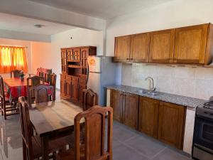 a kitchen with wooden cabinets and a table and a kitchen with a dining room at Casa cairo in Ostende +19 photos