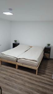 a bed in a room with a white wall at Wambacher Ferienwohnung in Schlangenbad