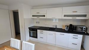 a kitchen with white cabinets and a black counter top at Wambacher Ferienwohnung in Schlangenbad