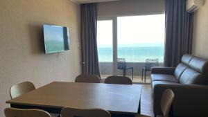 a living room with a table and a couch and a television at Oceano in Necochea