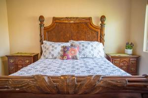 a wooden bed with two night stands and two pillows at Longer Stays for Travelers- Apt Blocks from Hospital, Downtown in Visalia