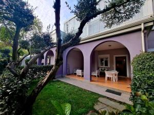 a purple house with a patio and a table at Villa Margot in Agropoli