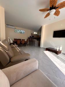 a living room with a couch and a ceiling fan at Almar in Olón