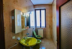 a bathroom with a yellow sink and two toilets at Ca Martin in Tresivio +18 photos