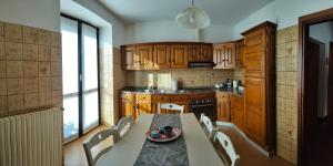 a kitchen with wooden cabinets and a table and chairs at Ca Martin in Tresivio