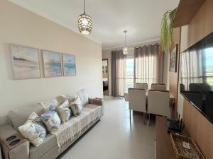 a living room with a couch and a dining room at Condomínio Reserva Almagre - MH in João Pessoa