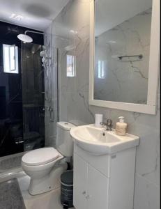 a bathroom with a toilet and a sink and a mirror at Nova Marine in Souda