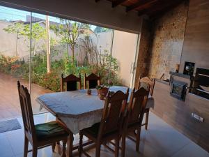 a dining room with a table and chairs and a large window at Quartos Festa do Peão Barretos in Barretos