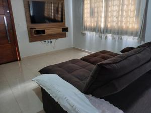 a living room with a couch and a television at Quartos Festa do Peão Barretos in Barretos