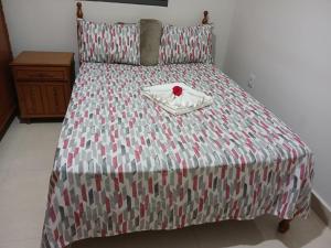 a bed with a red rose on top of it at Quartos Festa do Peão Barretos in Barretos