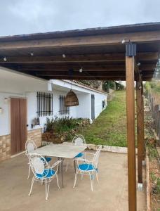 a patio with a table and chairs under a pergola at La caseta del llorer in Catadau