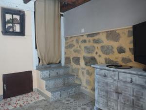 a room with a stone wall and a stone staircase at Winahost Casita Sierra de Madrid in Las Herreras