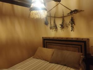 a bedroom with a bed and a chandelier at Winahost Casita Sierra de Madrid in Las Herreras