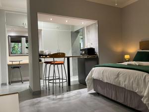 a bedroom with a bed and a kitchen with a bar at Luigi's Place in Pretoria +42 photos