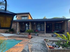 a brick house with a swimming pool in front of it at Luigi's Place in Pretoria