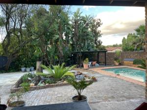 a backyard with a swimming pool and a garden at Luigi's Place in Pretoria