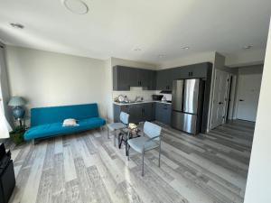 a living room with a blue couch and a kitchen at Pond view Walkout in Airdrie
