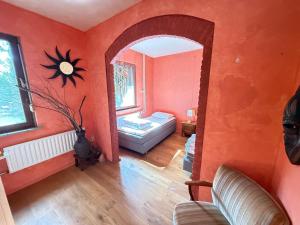 a living room with an orange wall at Stichting InnEssence Stokershorst in Nederweert-Eind
