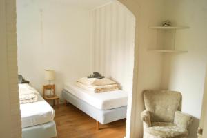 a room with two beds and a chair in it at Stichting InnEssence Stokershorst in Nederweert-Eind