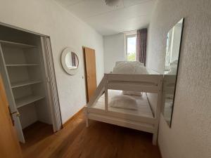 a small room with a bunk bed and a mirror at Stichting InnEssence Stokershorst in Nederweert-Eind