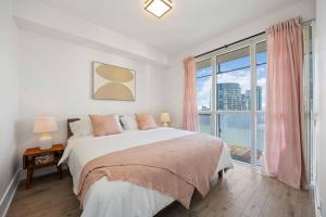 a bedroom with a bed and a large window at Condo by CN Tower & Rogers Centre in Toronto +15 photos