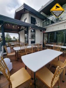 a white table and chairs in a restaurant at Salablanca Brand New Jacuzzi Heated Pool PS5 VR Cinema Fully AC Indoors Smart TVs with Netflix Disney Plus Large Balcony in Tagaytay
