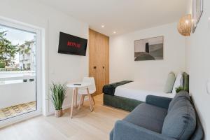 a room with a bed and a couch and a table at Póvoa Studios by Pomerania in Póvoa de Varzim