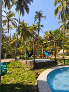 a resort with a swimming pool and palm trees at Mystic Beach Resort in Guachaca