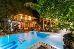 a swimming pool in front of a house at night at The One Hikkaduwa in Hikkaduwa