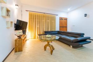 a living room with a couch and a coffee table at The One Hikkaduwa in Hikkaduwa