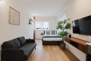 a living room with a couch and a bed at Póvoa Studios by Pomerania in Póvoa de Varzim