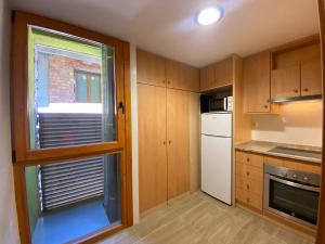 a kitchen with wooden cabinets and a window at Era de Caçador in Llavorsí
