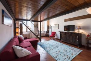 フィレンツェにあるFirenze Rentals Suite Proconsoloのリビングルーム(赤いソファ、テレビ付)