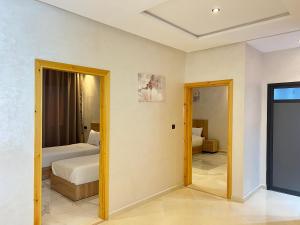 a room with two beds and a doorway to a bedroom at sahara house in Laayoune