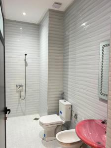 a bathroom with a toilet and a pink sink at sahara house in Laayoune +56 photos