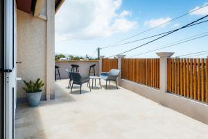 a patio with chairs and a table on a balcony at Villa du Ruisseau in Saint-Louis