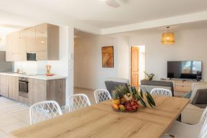 a kitchen and a table with a bowl of fruit on it at Villa du Ruisseau in Saint-Louis