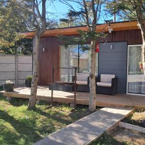 a house with a deck with two chairs on it at Tiny House Ruta 215 in Osorno
