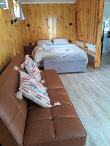 two pillows on a couch in a room with two beds at Tiny House Ruta 215 in Osorno