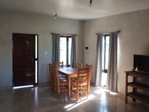a dining room with a wooden table and chairs at Cabaña gio in Potrero de Garay