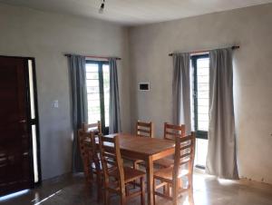 a dining room with a wooden table and chairs at Cabaña gio in Potrero de Garay +5 photos