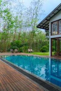 a house with a swimming pool and a wooden deck at Clara Villas Amithirigala in Avissawella